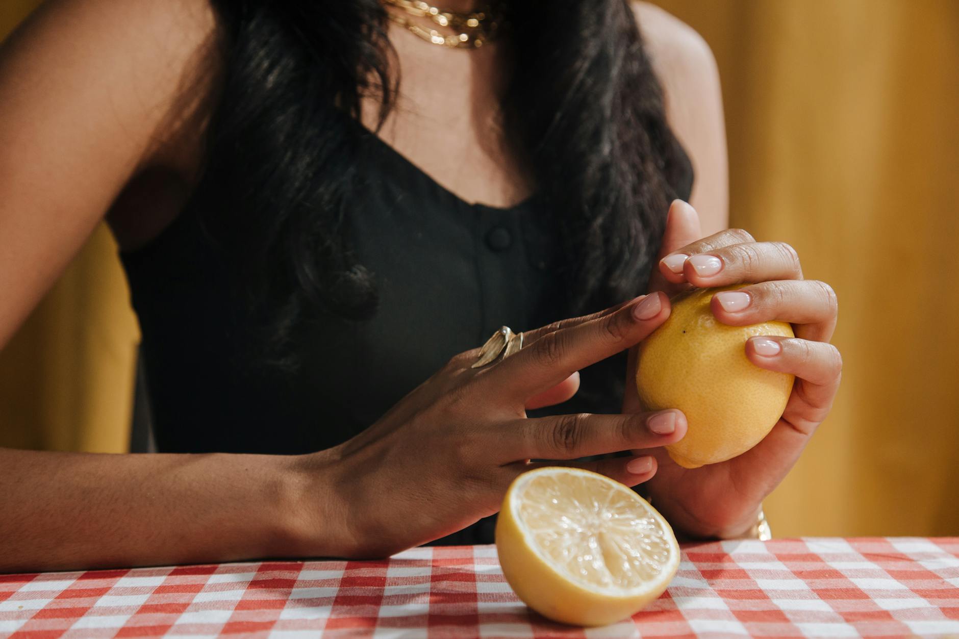 Close-up of hands holding a blue vibrator against a purple background