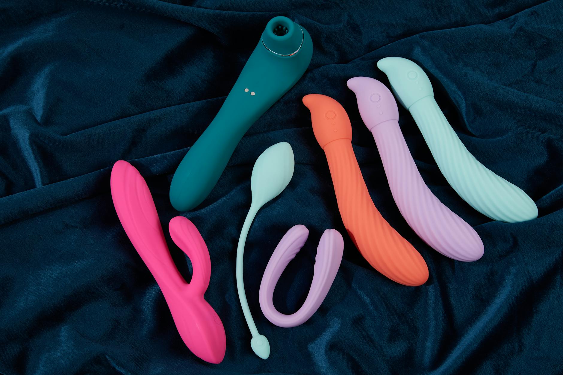 A couple stands together indoors, holding a modern vibrator, symbolizing reconnection and shared intimacy.