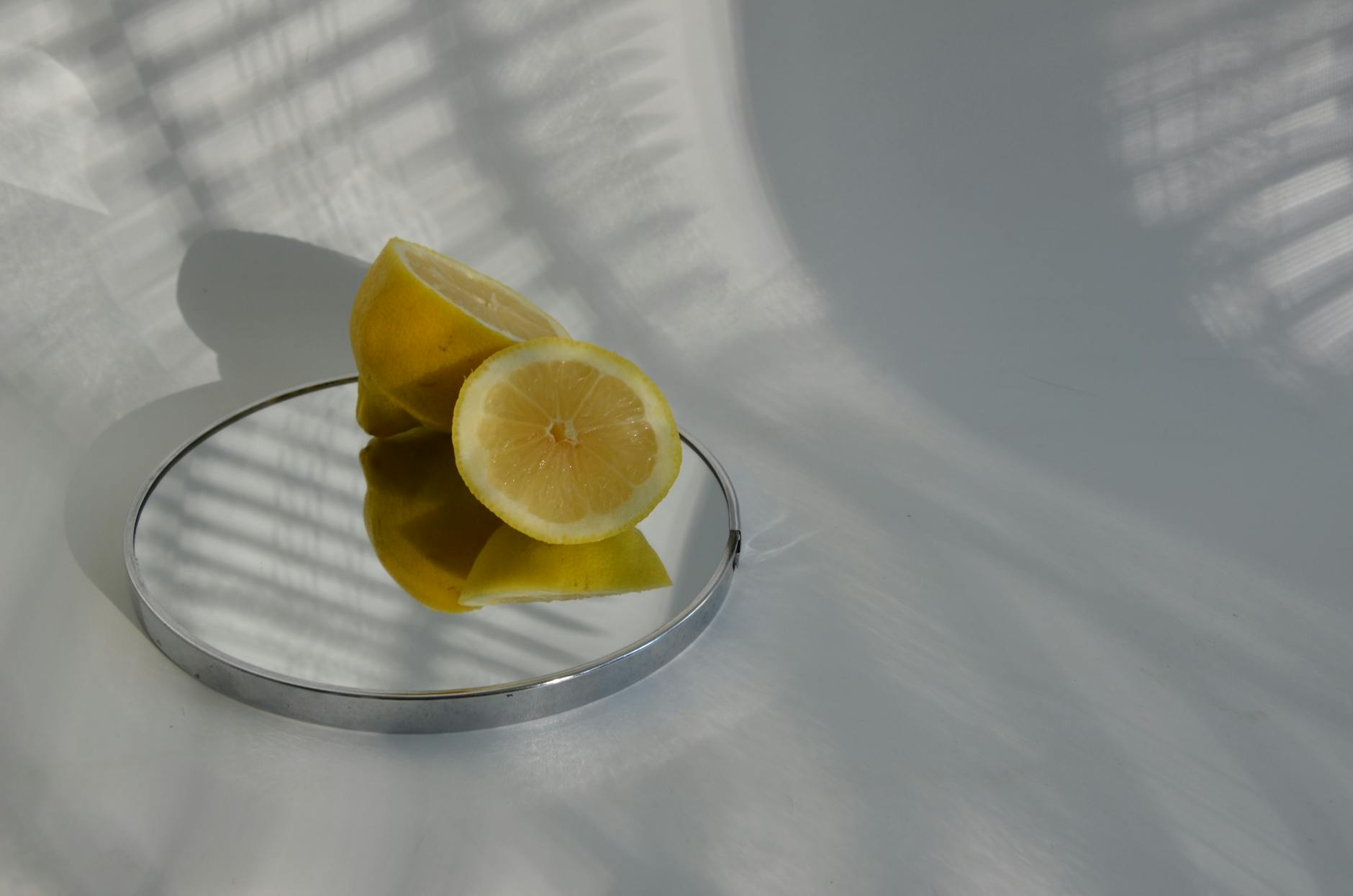 Yellow silicone vibrator surrounded by fresh fruit on bright yellow background