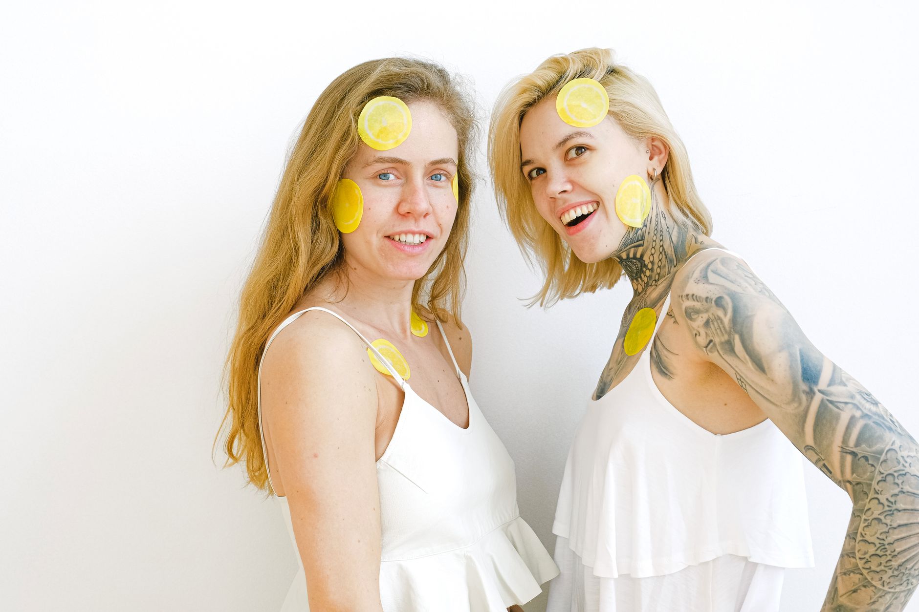 Woman laughing with lemon slices on her face, representing joy and pleasure