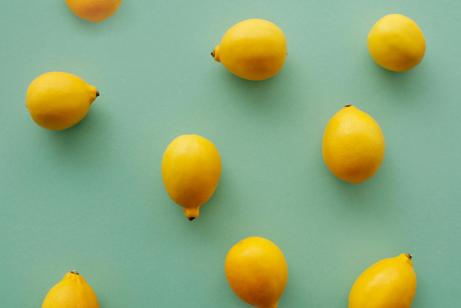Fresh bright yellow lemons on a pastel green background, symbolizing renewal and zest