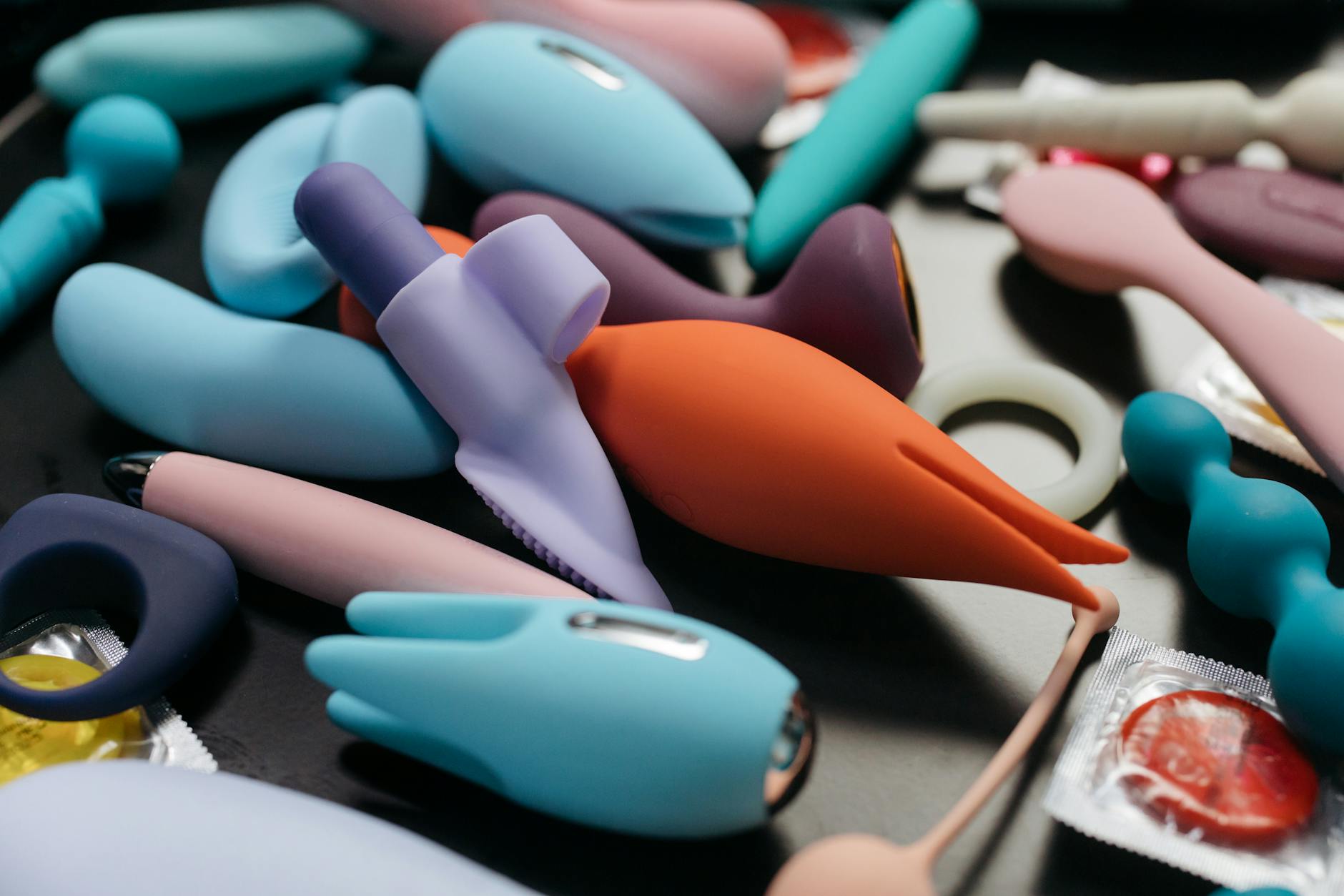 Hands holding a sleek blue clitoral vibrator against a purple background, symbolizing reconnection and self-intimacy