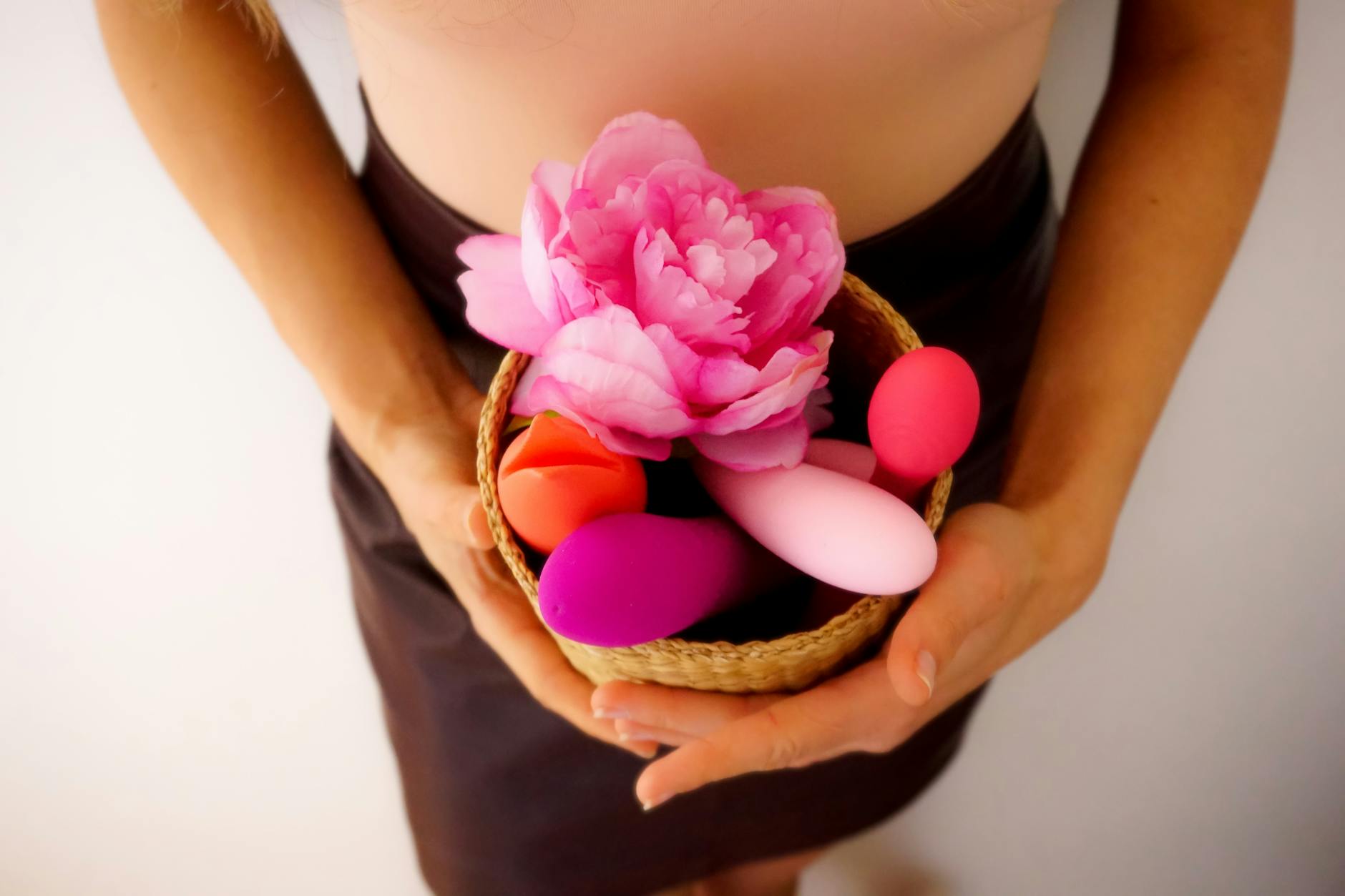 A blue clitoral vibrator surrounded by flowers and citrus slices on a bright yellow background
