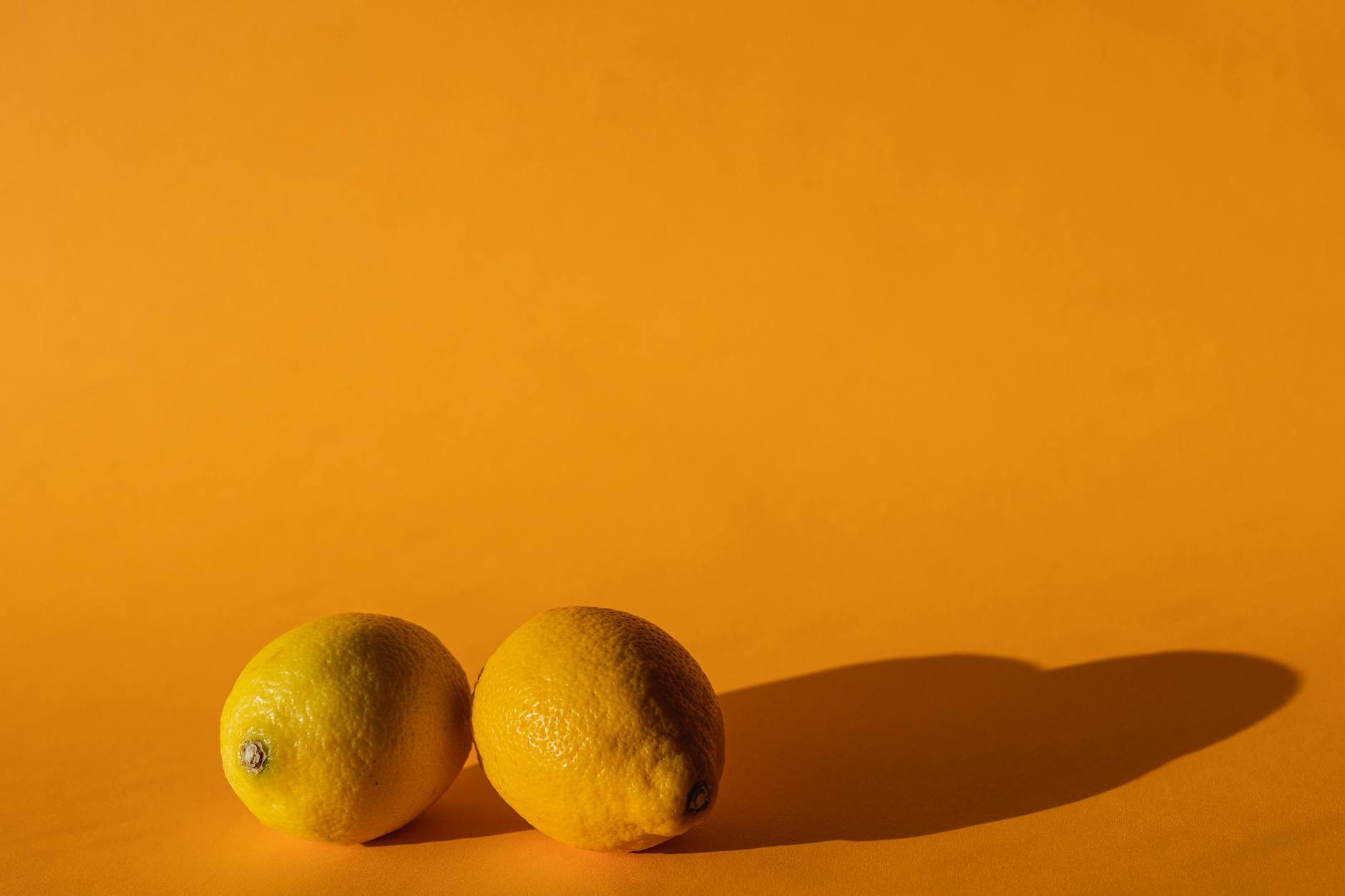 Ripe vivid lemons on a bright yellow background, symbolizing sensory reconnection